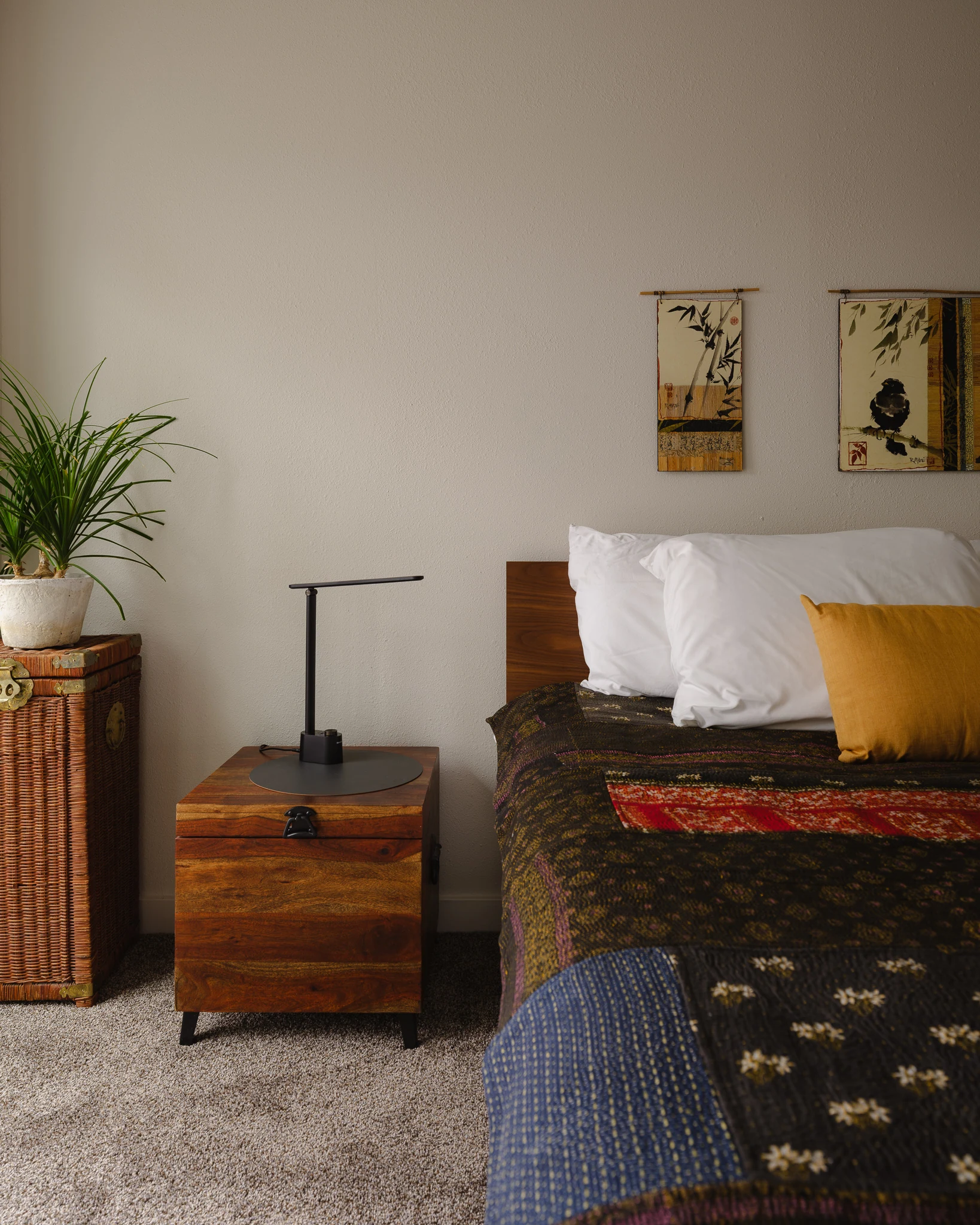 Guest bedroom nightstand styled with a woven trunk and framed art — interior design photography Bozeman Montana, Living Places Design Studio